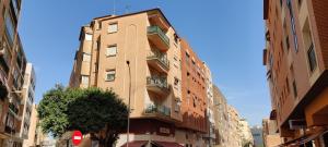 wysoki budynek z balkonami przy ulicy miejskiej w obiekcie Apartamento Málaga Centro w Maladze
