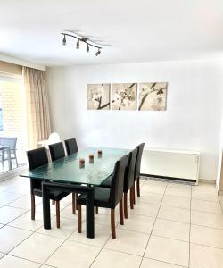 a dining room with a green table and chairs at Vakantieappartement Sauvignon Centrum Oostende in Ostend