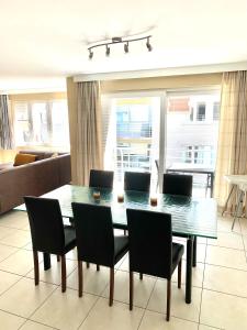 een eettafel en stoelen in de woonkamer bij Vakantieappartement Sauvignon Centrum Oostende in Oostende