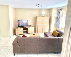 ein Wohnzimmer mit einem Sofa und einem TV in der Unterkunft Vakantieappartement Sauvignon Centrum Oostende in Ostende