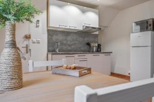 a kitchen with white cabinets and a wooden floor at Super studio climatisé in La Ciotat