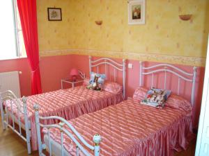 two beds in a bedroom with pink and yellow walls at Maison de 4 chambres avec terrasse amenagee a Valuejols 