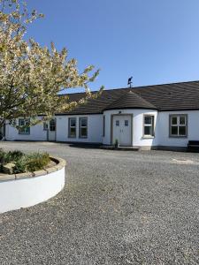 a white house with a gravel driveway at Portaferry self catering retreat in Portaferry