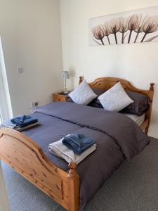 a bedroom with a wooden bed with towels on it at Portaferry self catering retreat in Portaferry
