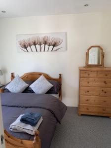 a bedroom with a bed and a dresser and a mirror at Portaferry self catering retreat in Portaferry