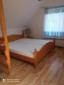a bedroom with a large wooden bed with white sheets at Agroturystyka pod Baranią Gorą in Kamesznica