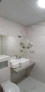 ハスコヴォにあるхотел ВИЗИЯの洗面台とトイレを備えた白いバスルーム