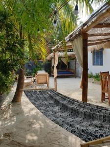 a patio with a hammock and chairs and a house at Déjà Blue in Paje