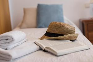 kapelusz i książka na łóżku z ręcznikami w obiekcie Avenida Playa 3 Rooms 2 baños w Kadyksie