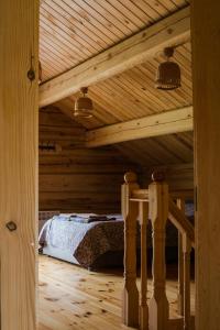 a bedroom with a bed in a wooden ceiling at Vila Juodenėnai in Žaugėdai +39 photos