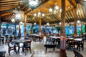 a dining room with tables and chairs in a restaurant at Dewi Sinta Hotel and Restaurant in Tanah Lot