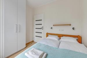 グダニスクにあるGdańsk Comfort Apartaments Old Town Minogiのベッドルーム1室(ベッド2台、クローゼット付)