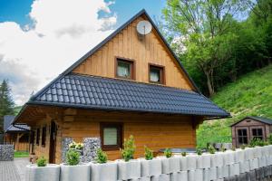 a log cabin with a black roof at Chata Snezienka in Oščadnica