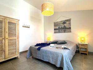 a bedroom with a bed and two tables with lamps at Le Clos des Vieux Moulins in La Flotte