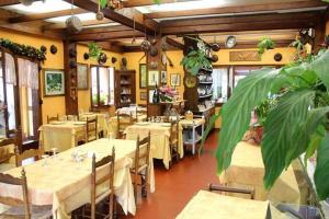 - un restaurant avec des tables et des chaises dans une salle dans l'établissement Albergo Ristorante Da Carlino, à Castelnuovo di Garfagnana