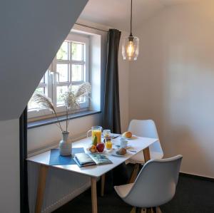 a white table with fruit on it next to a window at Weberhof Ferienapartments in Rostrup am Westufer des Zwischenahner Meers in Bad Zwischenahn