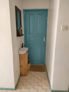 baño con puerta azul y lavamanos en Déjà Blue en Paje