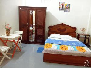 a bedroom with a bed and a table and a chair at Noel Homestay in Hiếu Xương