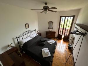 Un dormitorio con una cama y un ventilador de techo. en La Casa sulla Collina, en Polcenigo