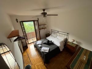 Un dormitorio con una cama y un ventilador de techo. en La Casa sulla Collina, en Polcenigo