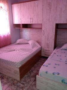 a small bedroom with two beds and cabinets at DRINI in Velipojë