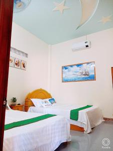 a bedroom with two beds and a moon at Noel Homestay in Hiếu Xương