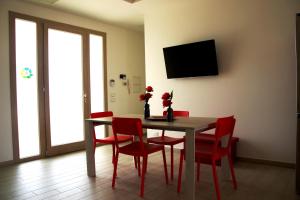 アレーツィオにあるEco Villa con piscina privata e indipendenteのダイニングルーム(テーブル、赤い椅子付)