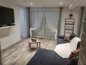 a living room with a couch and a table at Loft du sud ouest av garage in Laplume +5 photos