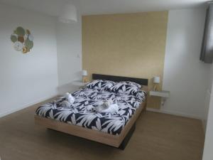 two stuffed animals laying on a bed in a bedroom at Loft du sud ouest av garage in Laplume