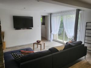 a living room with a couch and a large window at Loft du sud ouest av garage in Laplume