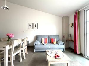 a living room with a couch and a table at Le Clos des Vieux Moulins in La Flotte