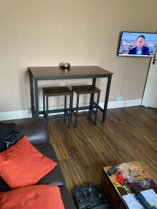 a living room with a table and a tv at Apartments 41 Hastings in Hastings