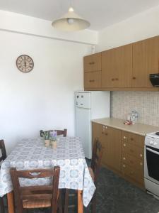 a kitchen with a table with chairs and a refrigerator at Petros Family in Agios Ioannis Tinos