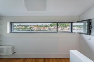 an empty white room with a large window at Art Douro Historic Distillery in Vila Nova de Gaia