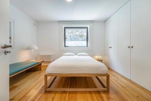 biała sypialnia z łóżkiem i oknem w obiekcie Art Douro Historic Distillery w mieście Vila Nova de Gaia