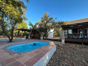 a swimming pool in a yard next to a house at Elements Private Golf Reserve Unit 149 or 150 in Bela-Bela