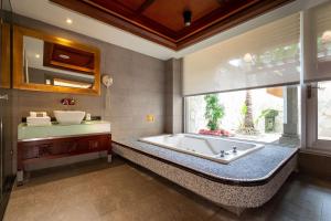 baño con bañera, lavabo y ventana en In-stone Motel en Taipéi