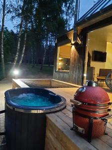 a hot tub on a deck next to a house at BRENDIS -'Virš Ąžuolų' - Forest SPA - FREE jacuzzi in Paplatelė