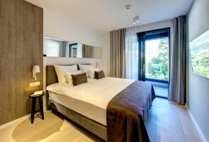 a bedroom with a large bed and a large window at Four Blue Seasons - Luxury Apartments Dubrovnik in Dubrovnik