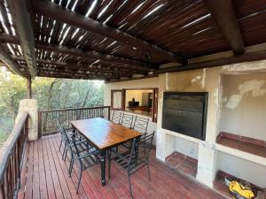 a wooden table and chairs on a deck with a television at Elements Private Golf Reserve Unit 149 or 150 in Bela-Bela