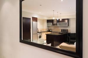 a mirror reflecting a kitchen and a living room at Icon Luxury Apartments - Central Cape Town in Cape Town