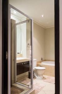 a bathroom with a toilet and a sink and a tub at Icon Luxury Apartments - Central Cape Town in Cape Town