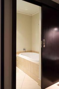 a bathroom with a bath tub next to a door at Icon Luxury Apartments - Central Cape Town in Cape Town