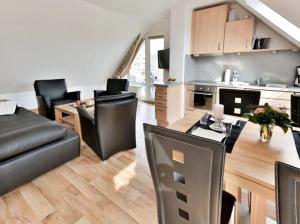 ein Wohnzimmer mit einem Sofa und einem Tisch in der Unterkunft Ferienwohnung 39 Mauersegler - Urlaub in der Natur in Timmendorfer Strand