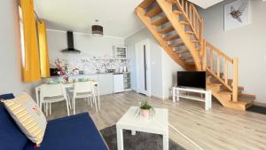 a living room with a blue couch and a kitchen at Domki Agi in Jastrzębia Góra