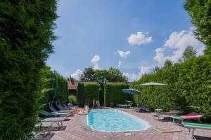 a swimming pool with chairs and people sitting around it at Villa Garden Hotel in Solochyn