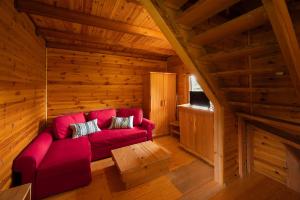 a living room with a red couch in a cabin at Chalets Zelena Vrata in Fužine