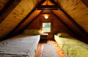 1 Schlafzimmer mit 2 Betten im Dachgeschoss in der Unterkunft Chalets Zelena Vrata in Fužine