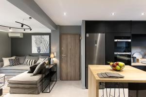 une cuisine et un salon avec un canapé et une table dans l'établissement GreyHouse Corfu διαμέρισμα στο κέντρο τις Κέρκυρας, à Ágios Rókkos