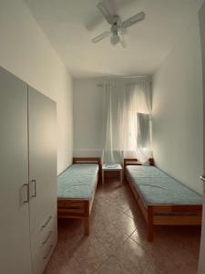 1 dormitorio con 2 camas individuales y ventana en Casa Vacanze , Scoglitti en Scoglitti